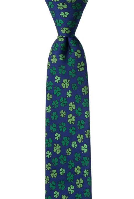 A navy blue necktie with an all-over green shamrock and clover pattern, shown tied at the top against a plain white background.